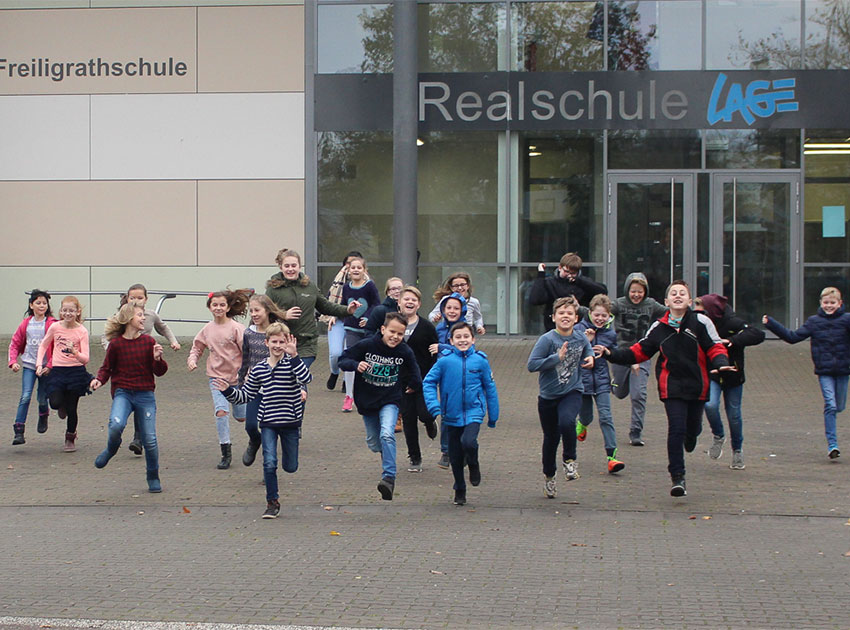 Kinder die auf dem Schulhof laufen