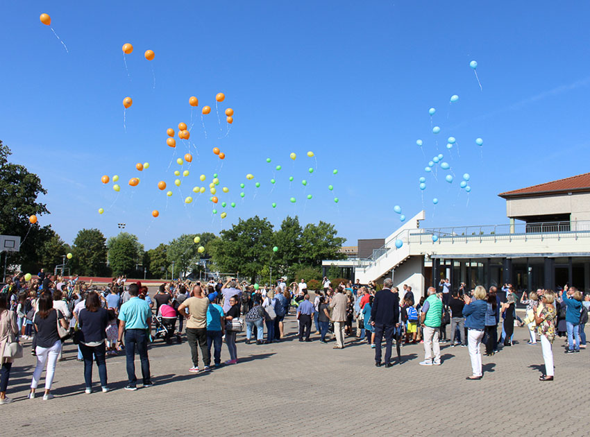 Auf dem Schulhof werden Luftballons steigen gelassen