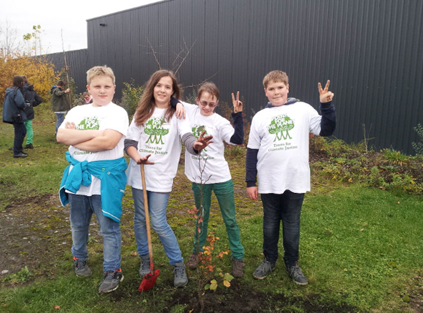 Vier Kinder beim Pflanzen eines Baumes